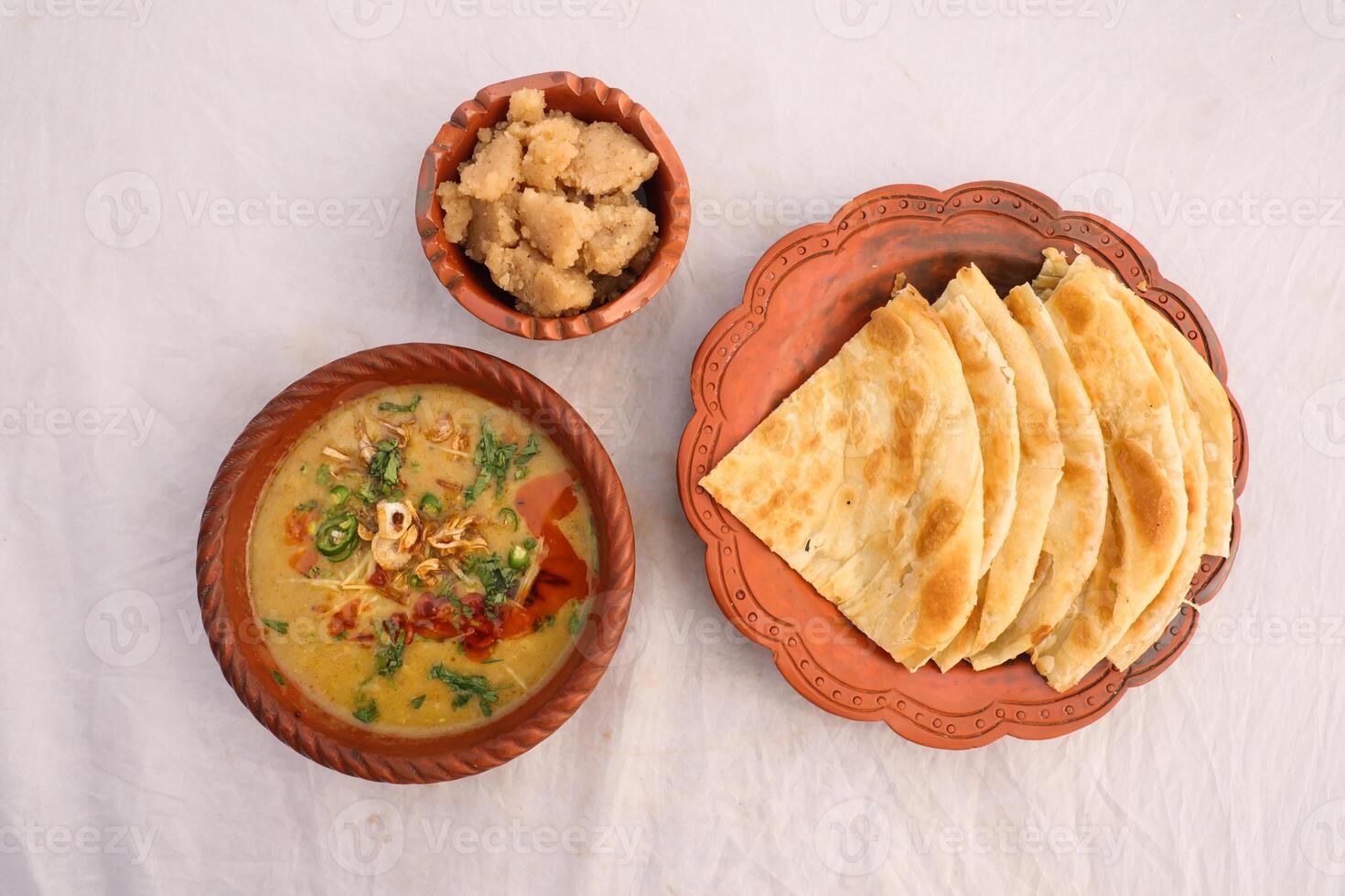 Desi breakfast, haleem, halim, dhaleem, halwa and paratha served in dish isolated on background top view of bangladesi breakfast photo