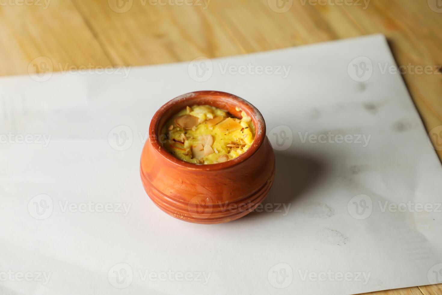 Firni, phirni anf kheer with nuts served in pot isolated on mat top view of indian, bangali and pakistani dessert mithai photo