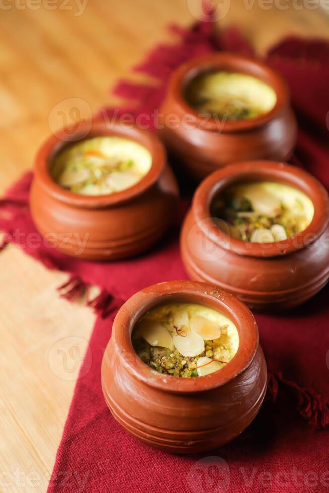 firni, phirni y kheer con nueces servido en maceta aislado en estera parte superior ver de indio, bangali y pakistaní postre mithai foto