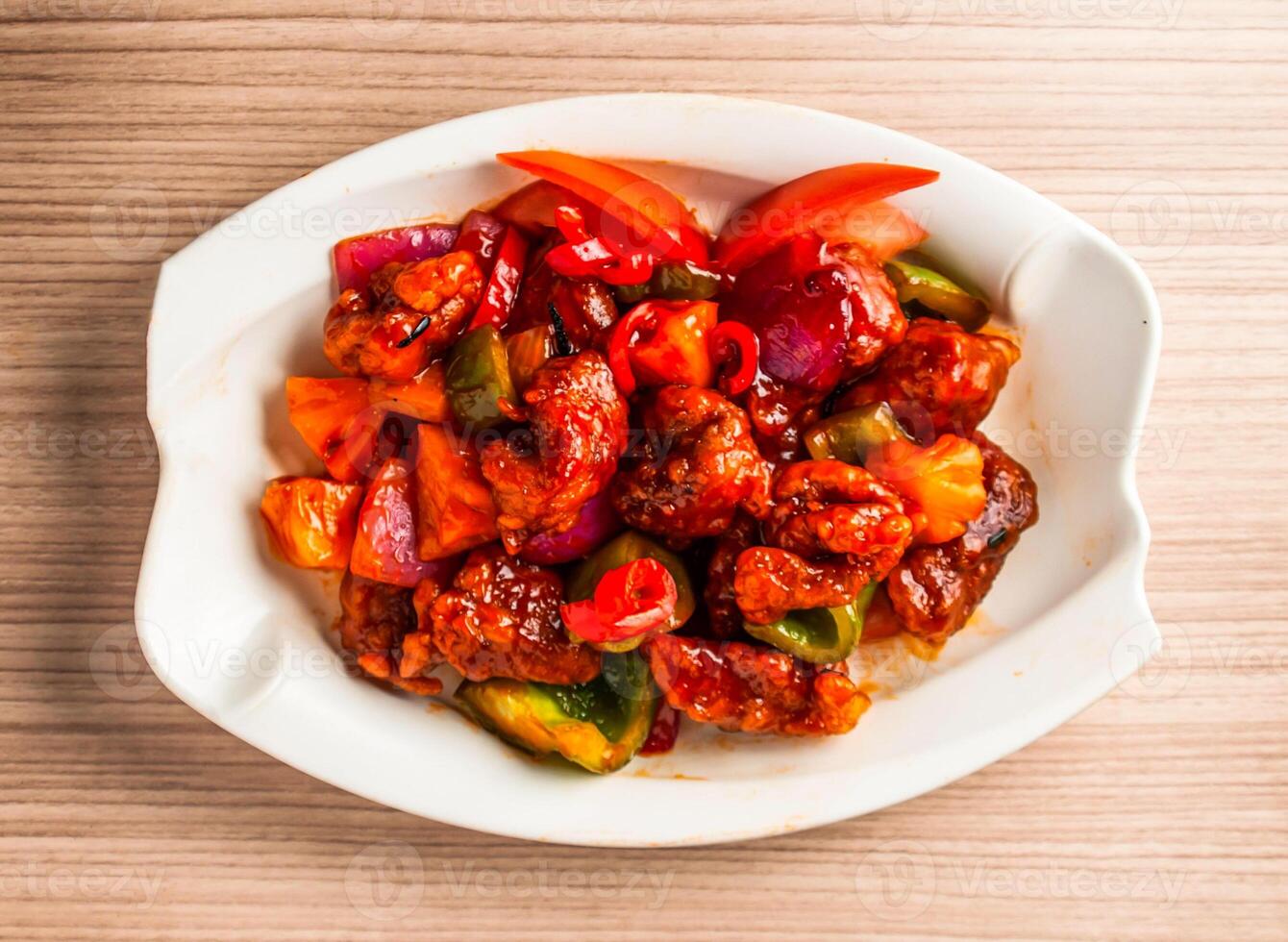 fried ribs with pineapple, tomato and bell pepper served in dish isolated on table top view of hong kong food photo