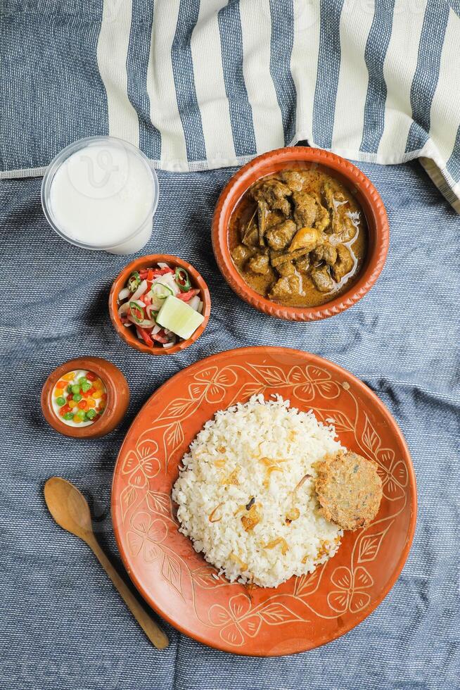 carne de vaca Chui jhal combo con pulao arroz, shami kebab, korma carahi, kala buna, boondi rabi, borhaní y ensalada servido en plato aislado en estera parte superior ver de indio y bangladeshi comida foto