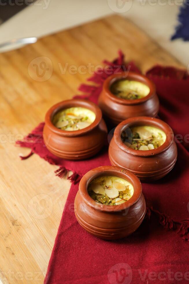 Firni, phirni anf kheer with nuts served in pot isolated on mat top view of indian, bangali and pakistani dessert mithai photo