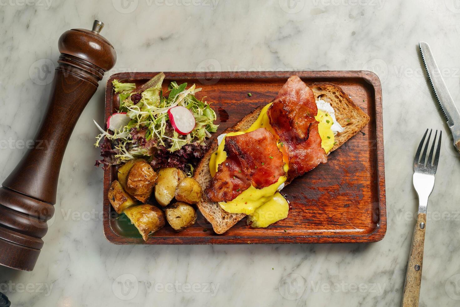 Eggs Benedict wih bread, meat, salad and potato served in dish isolated on marble background top view on hong kong food photo