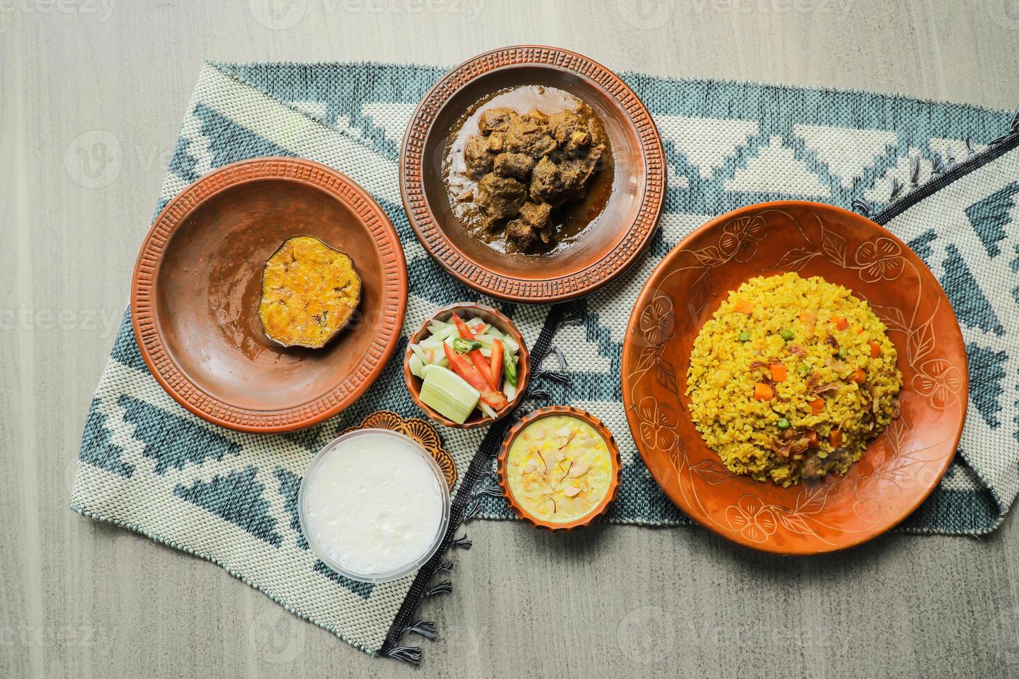 Haash Bhuna Khichuri Combo with egg plant, korma karahi, meat, salad, borhani and firni served in dish isolated on mat top view of indian and bangladeshi food photo