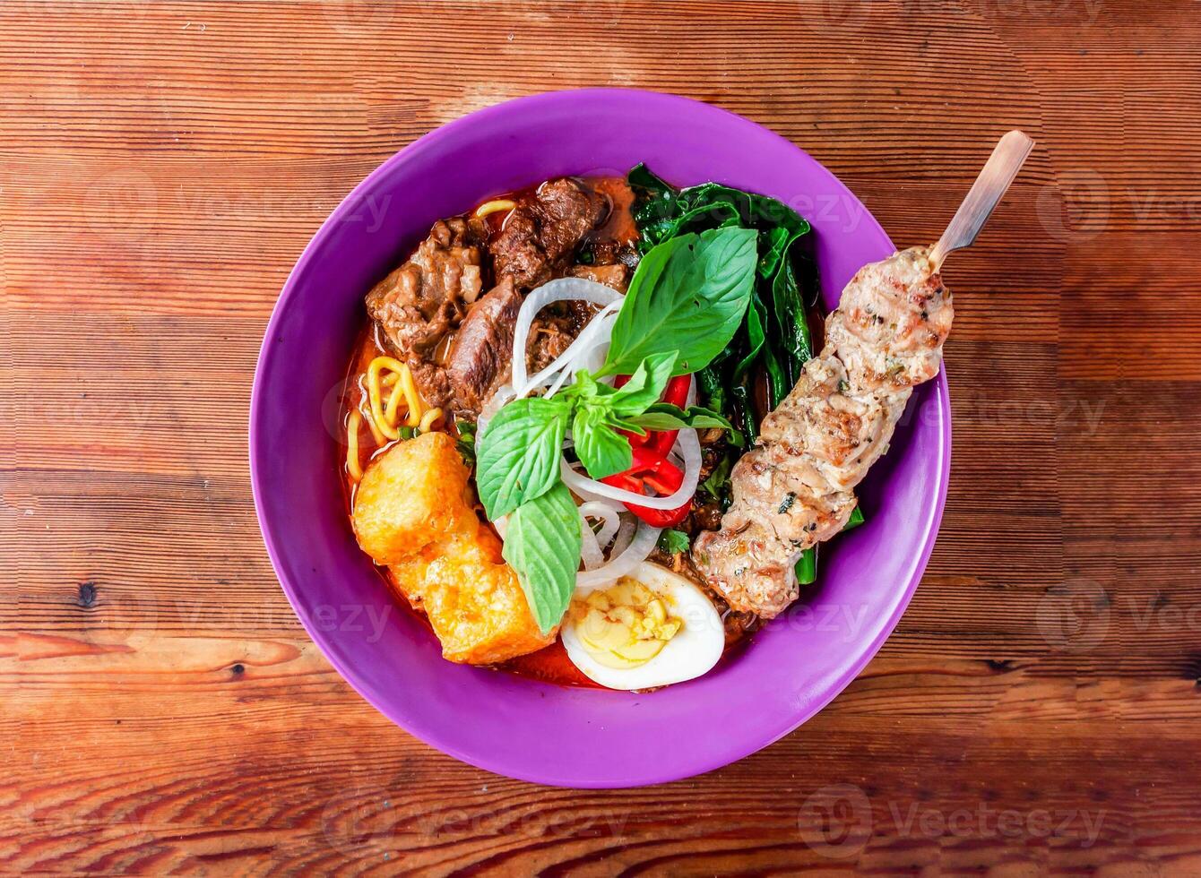 carne de vaca fideos sopa con brocheta servido en plato aislado en de madera mesa parte superior ver de hong kong comida foto