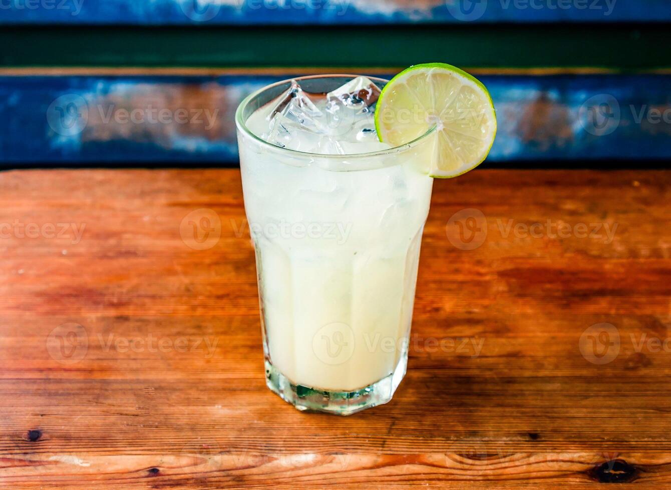 served in glass topping with lemon slice and ice cube isolated on wooden table side view of hong kong drink photo