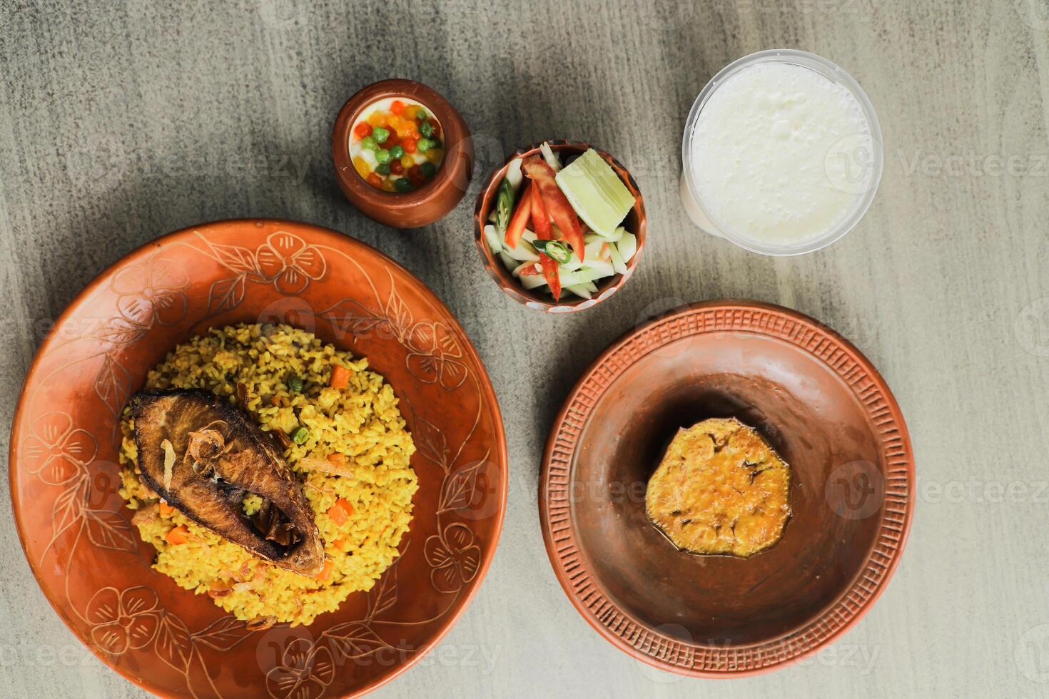 hilsa kichuri combo con ensalada, berenjena, borhaní y boondi rabi servido en plato aislado en estera parte superior ver de indio y bangladeshi comida foto