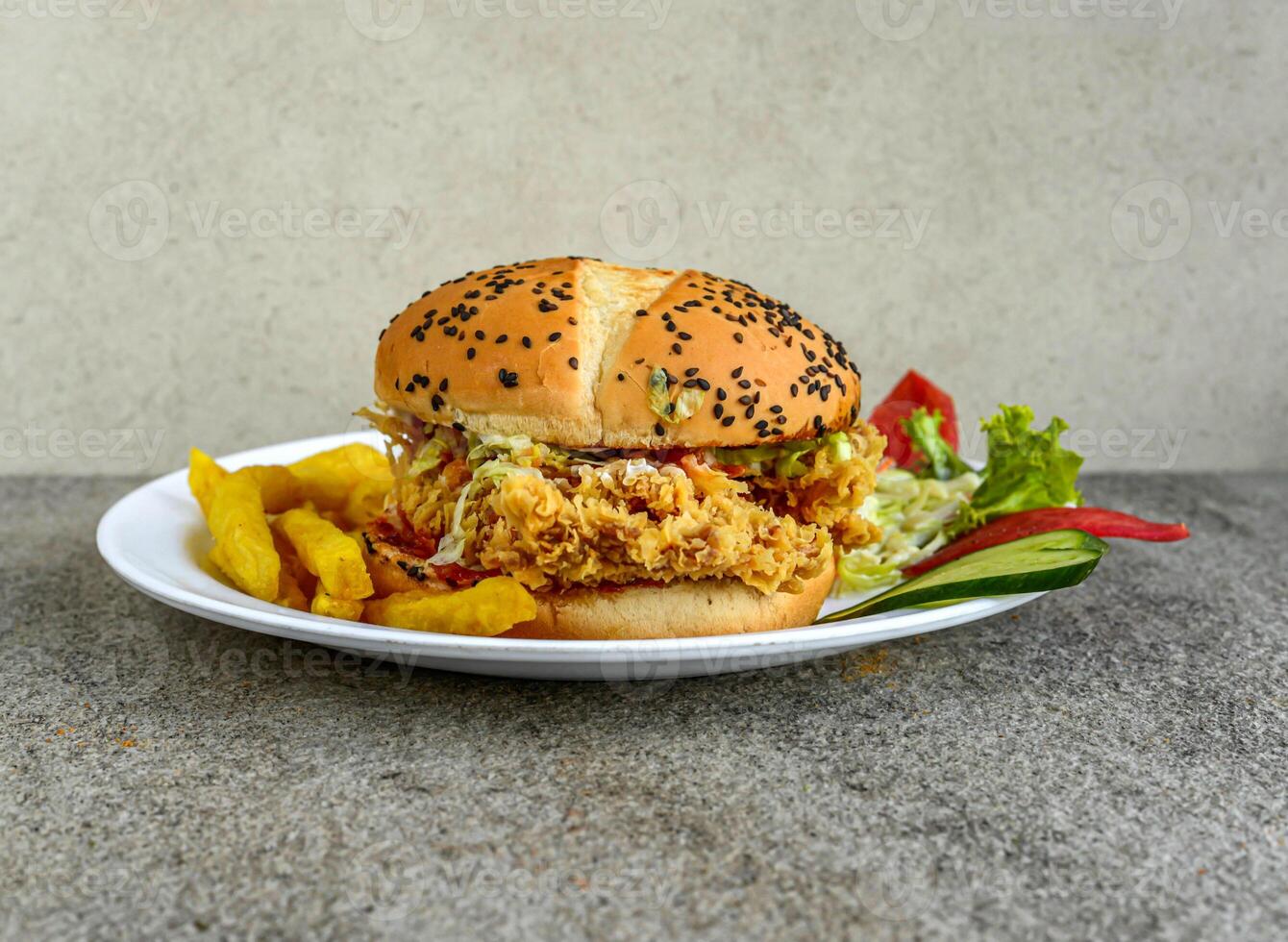 Crispy Chicken Zinger Burger with french fries and salad served in dish isolated on grey background side view of indian spices and pakistani food photo