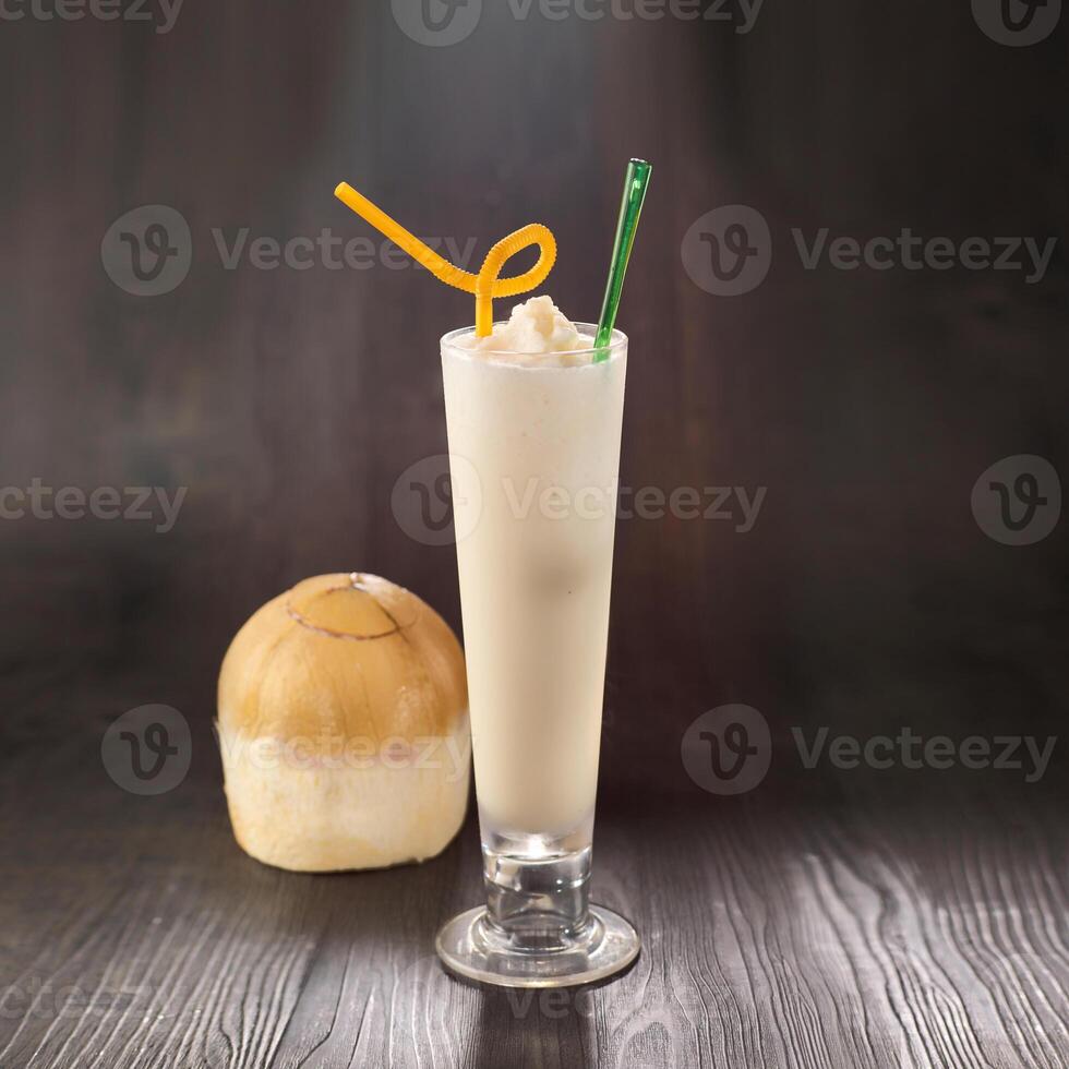 Thai Coconut Milkshake with straw served in glass isolated on table side view healthy morning drink photo