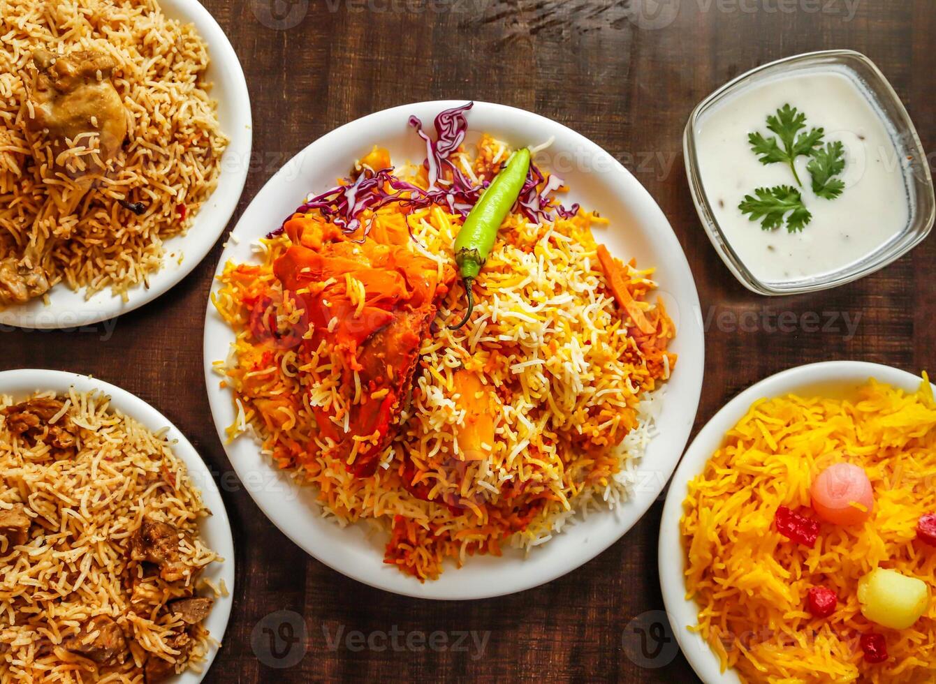 Assorted biryani, pulao with beef, chicken and zarda color ful rice served in plate isolated wooden background top view indian sweet and pakistani dessert food photo