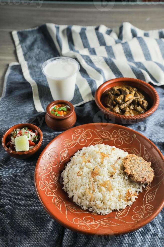 carne de vaca Chui jhal combo con pulao arroz, shami kebab, korma carahi, kala buna, boondi rabi, borhaní y ensalada servido en plato aislado en estera parte superior ver de indio y bangladeshi comida foto