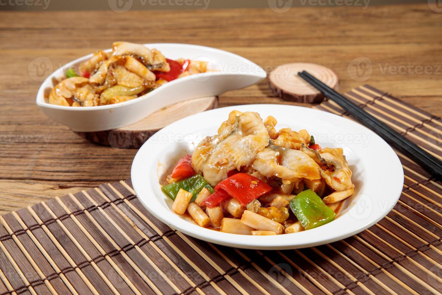 Sea bream fillet with lotus root with chopsticks served in dish isolated on mat top view on wooden table Hong Kong food photo