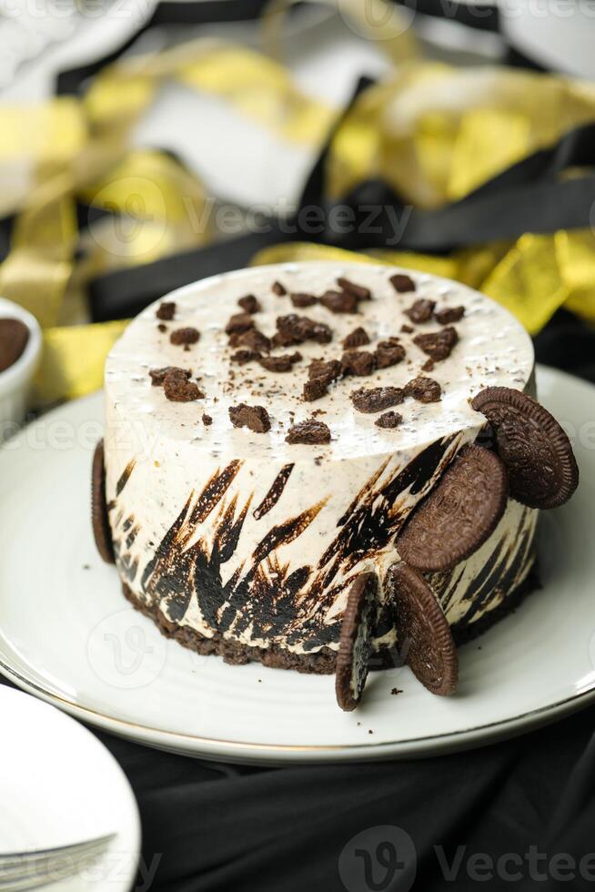 Oreo Cheesecake include chocolate, cream, sugar with fork and flowers served in plate isolated on napkin side view of cafe food photo