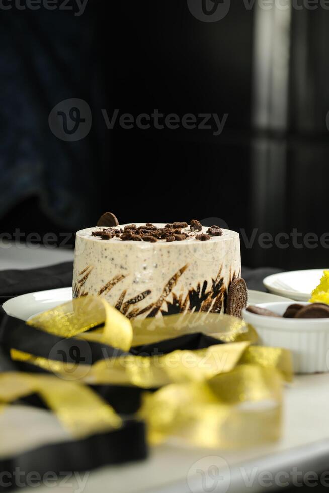 Oreo Cheesecake include chocolate, cream, sugar with fork and flowers served in plate isolated on napkin side view of cafe food photo