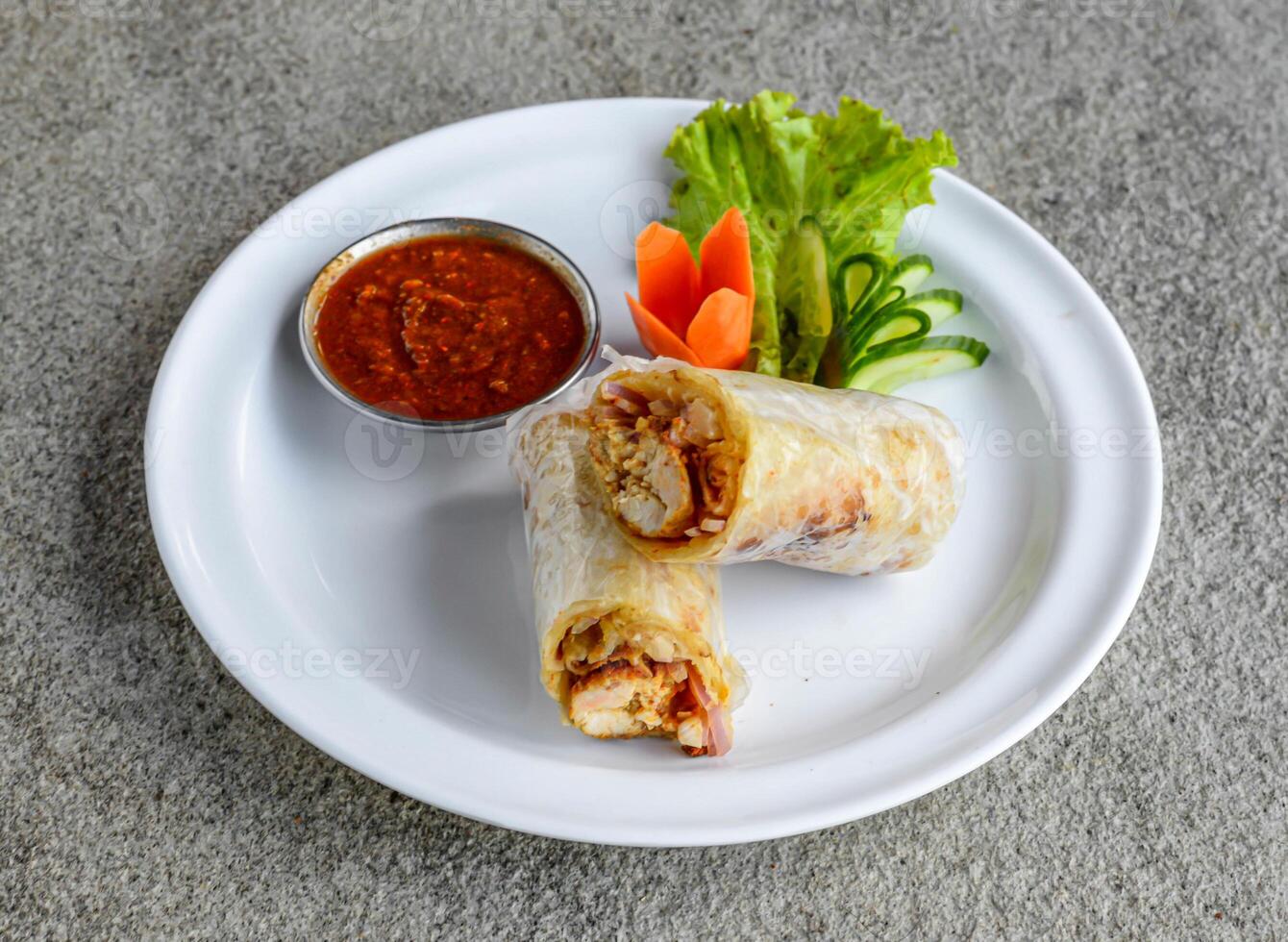 chicken chutney roll with chili sauce served in dish isolated on grey background side view of indian spices and pakistani food photo