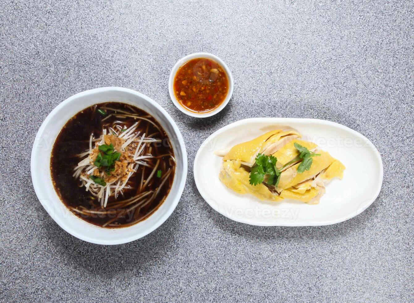 tailandés arroz fideos en sopa con hai nam pollo servido en cuenco aislado en gris antecedentes parte superior ver de hong kong comida foto