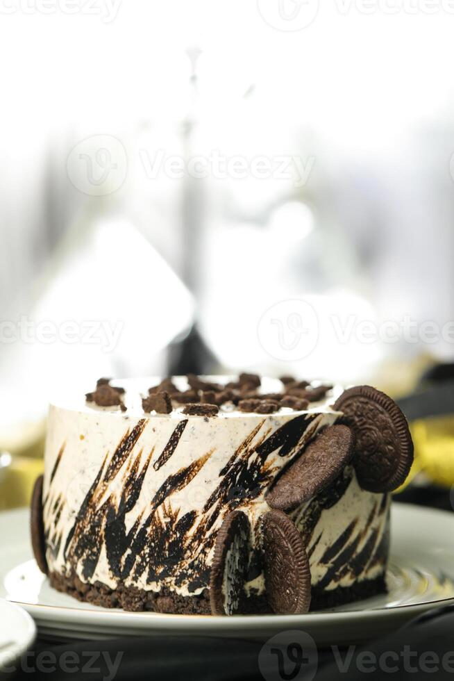 Oreo Cheesecake include chocolate, cream, sugar with fork and flowers served in plate isolated on napkin side view of cafe food photo