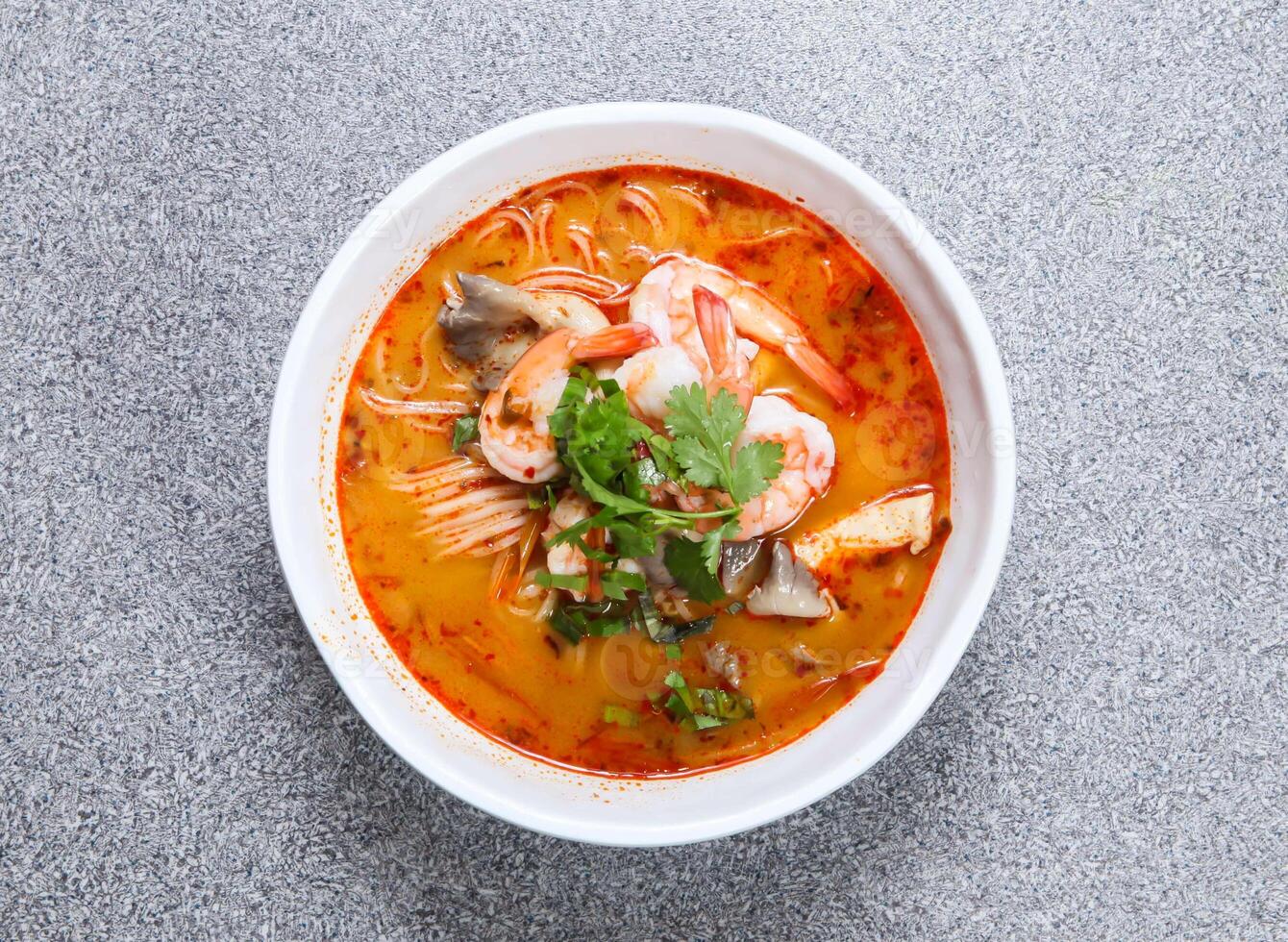 thai rice noodle in tom yum kung soup served in soup isolated on grey background top view of hong kong food photo