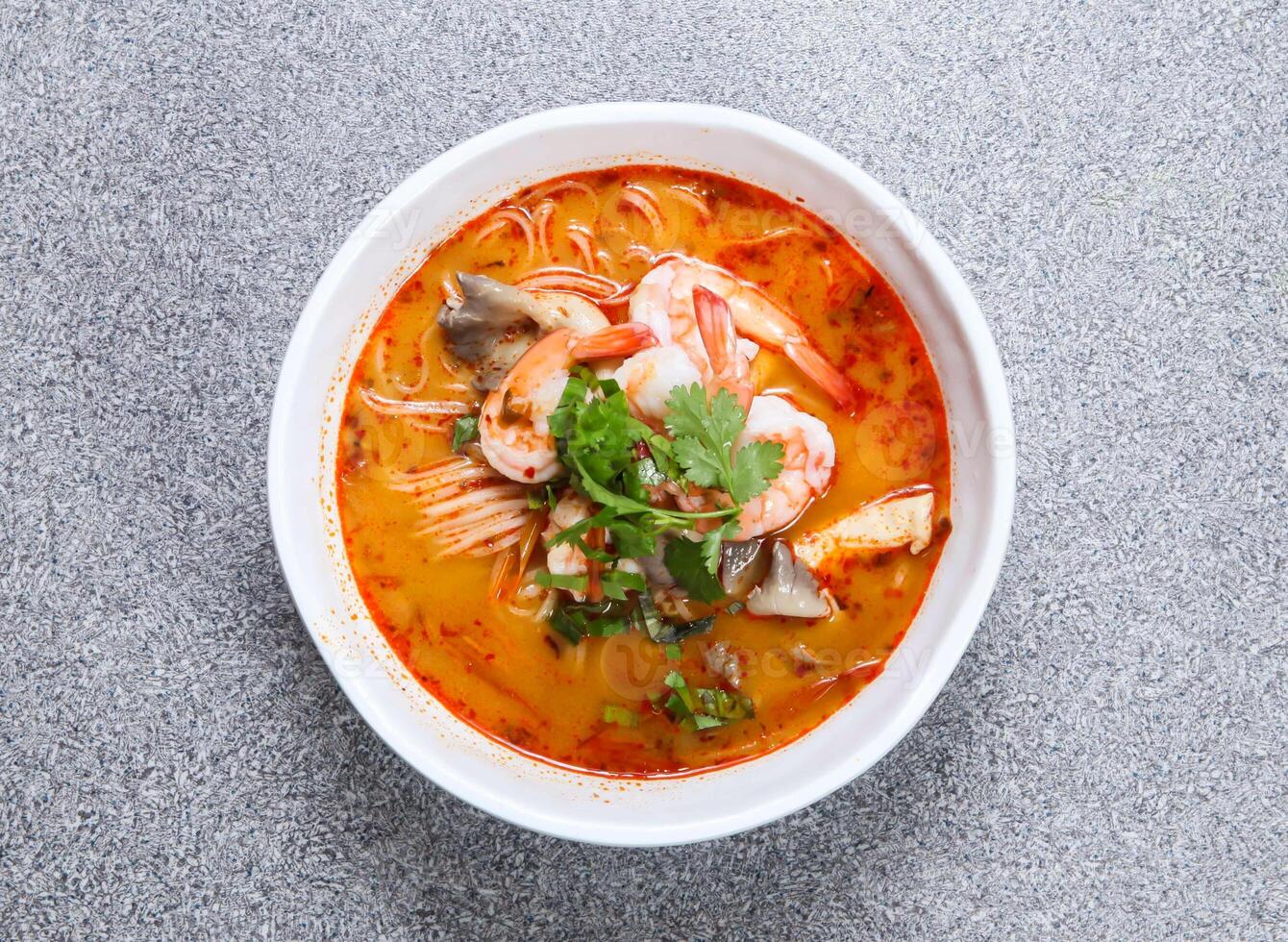 tailandés arroz fideos en tom ñam kung sopa servido en sopa aislado en gris antecedentes parte superior ver de hong kong comida foto