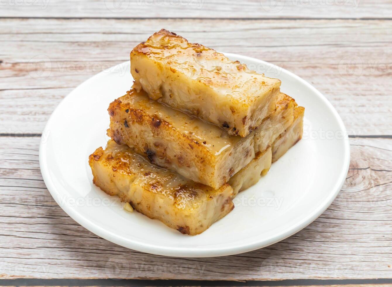 fried white turnip cake served in dish isolated on wooden table top view hong kong food photo