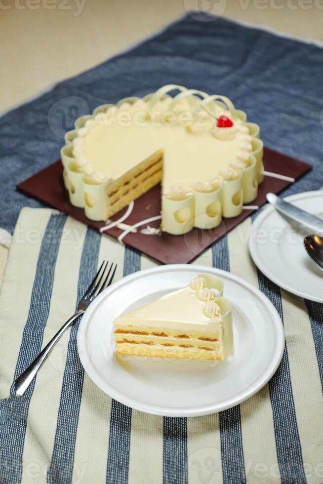 Vanilla Cake slice include cream, sugar, red berry served in plate isolated on napkin side view of cafe food photo