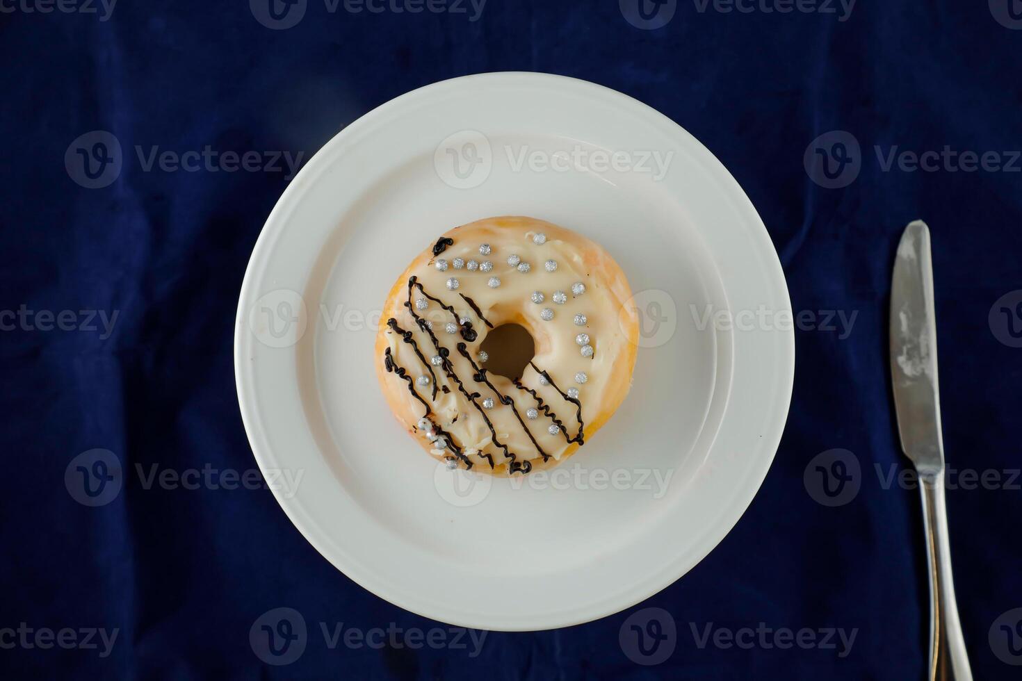 White Chocolate Donut served in plate isolated on blue background top view of baked food breakfast on table photo