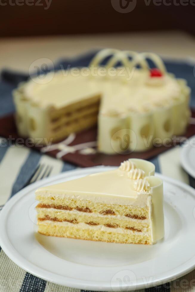 Vanilla Cake slice include cream, sugar, red berry served in plate isolated on napkin side view of cafe food photo