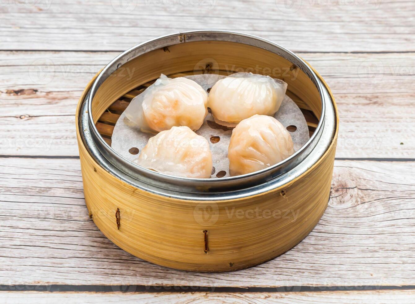 steam shrimp dumplings served in dish isolated on wooden table top view hong kong food photo