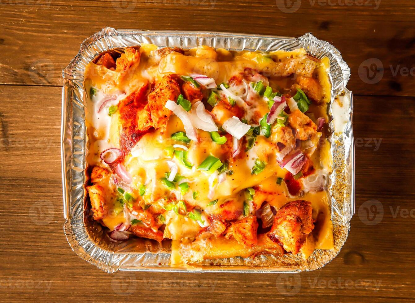 pizza loaded fries served in dish isolated on wooden background top view of indian spices and pakistani food photo