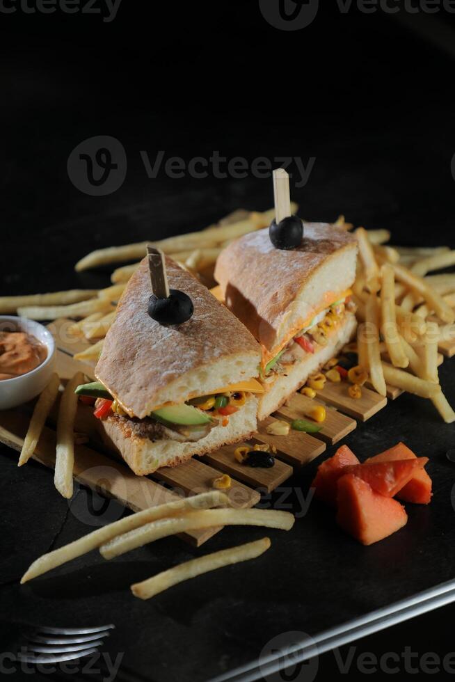 Spicy Southwest Chicken Sandwich with fries and mayonnaise dip served in tray isolated on dark background side view of breakfast food photo