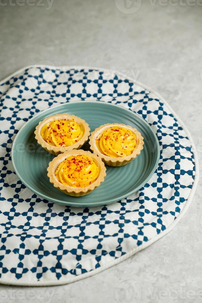 Lemon Tart muffin cup cake served in plate isolated on napkin side view of cafe baked food on background photo