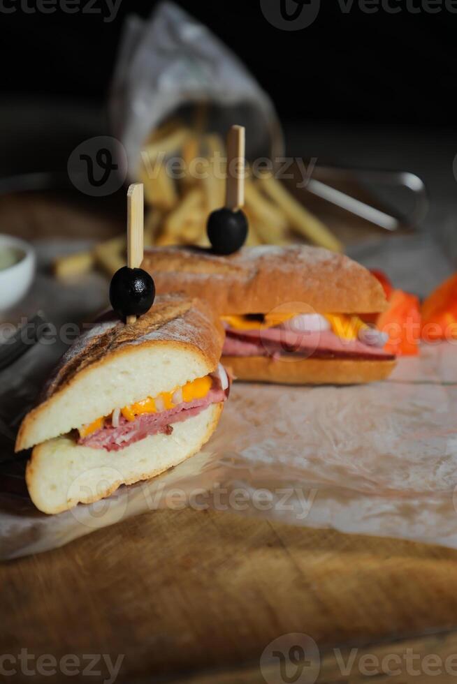 Robust Roast Beef Cheddar Sandwich with mayonnaise dip with fries served in wooden board isolated on napkin side view of breakfast food photo