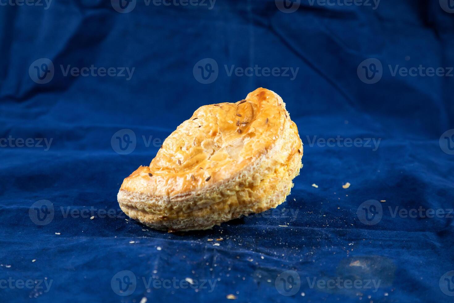 Beef Turnover isolated on blue background side view of savory snack food photo