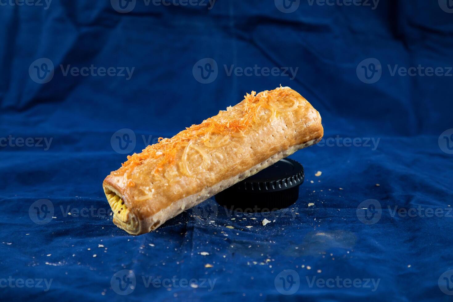 Beef Puff Roll isolated on blue background side view of savory snack food photo