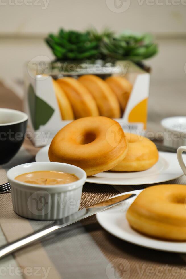 llanura rosquillas con inmersión y taza de café aislado en servilleta lado ver de horneado comida desayuno en mesa foto