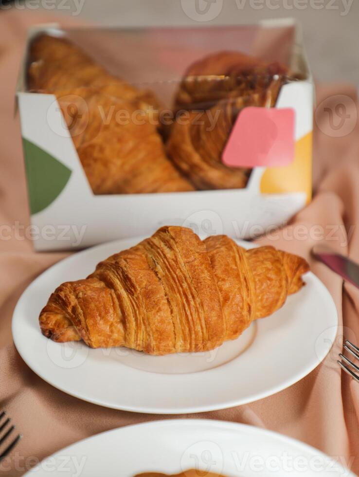 Plain Croissant served in plate side view of french breakfast baked food item on grey background photo