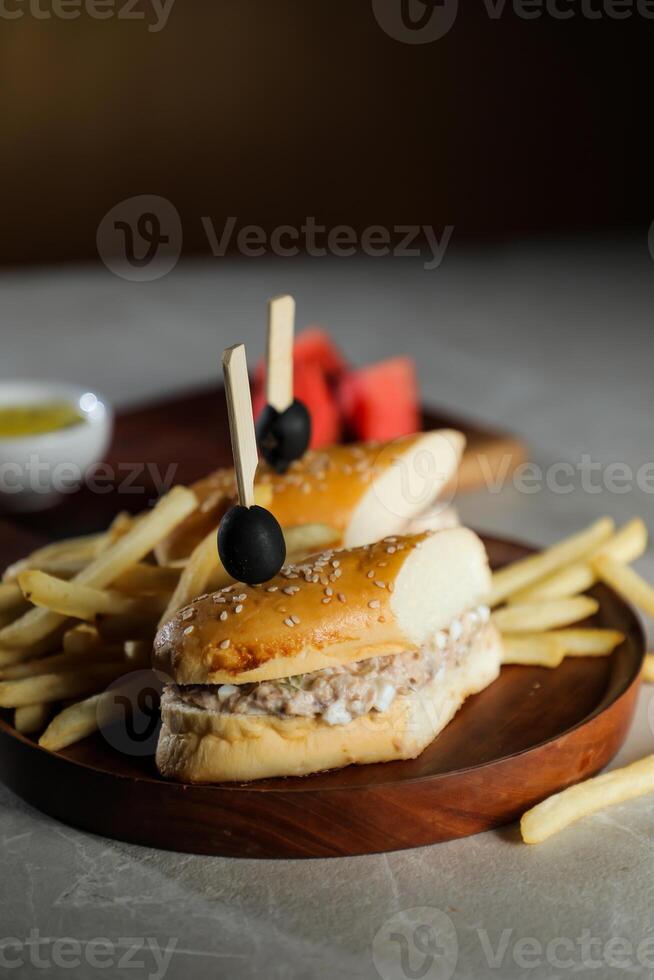 atún huevo emparedado con papas fritas y mayonesa inmersión servido en de madera tablero aislado en oscuro antecedentes lado ver de desayuno comida foto