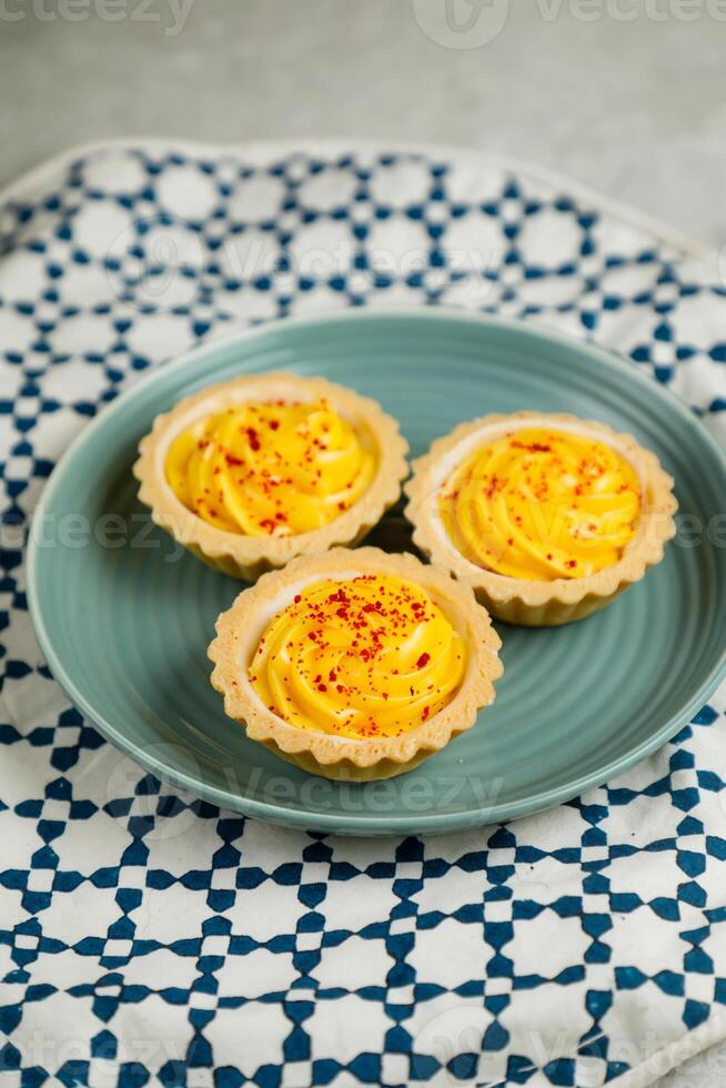 Lemon Tart muffin cup cake served in plate isolated on napkin side view of cafe baked food on background photo