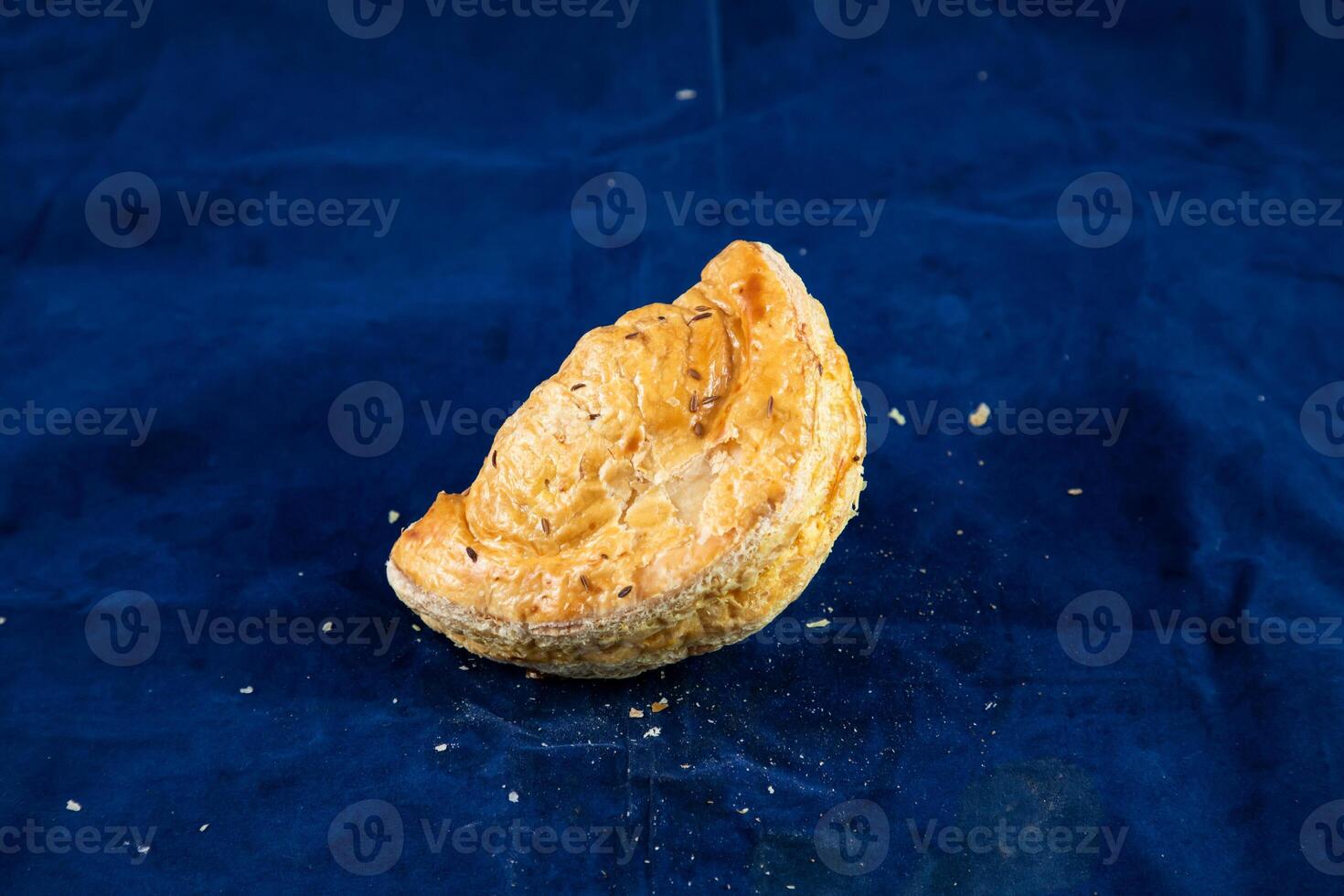 Beef Turnover isolated on blue background side view of savory snack food photo