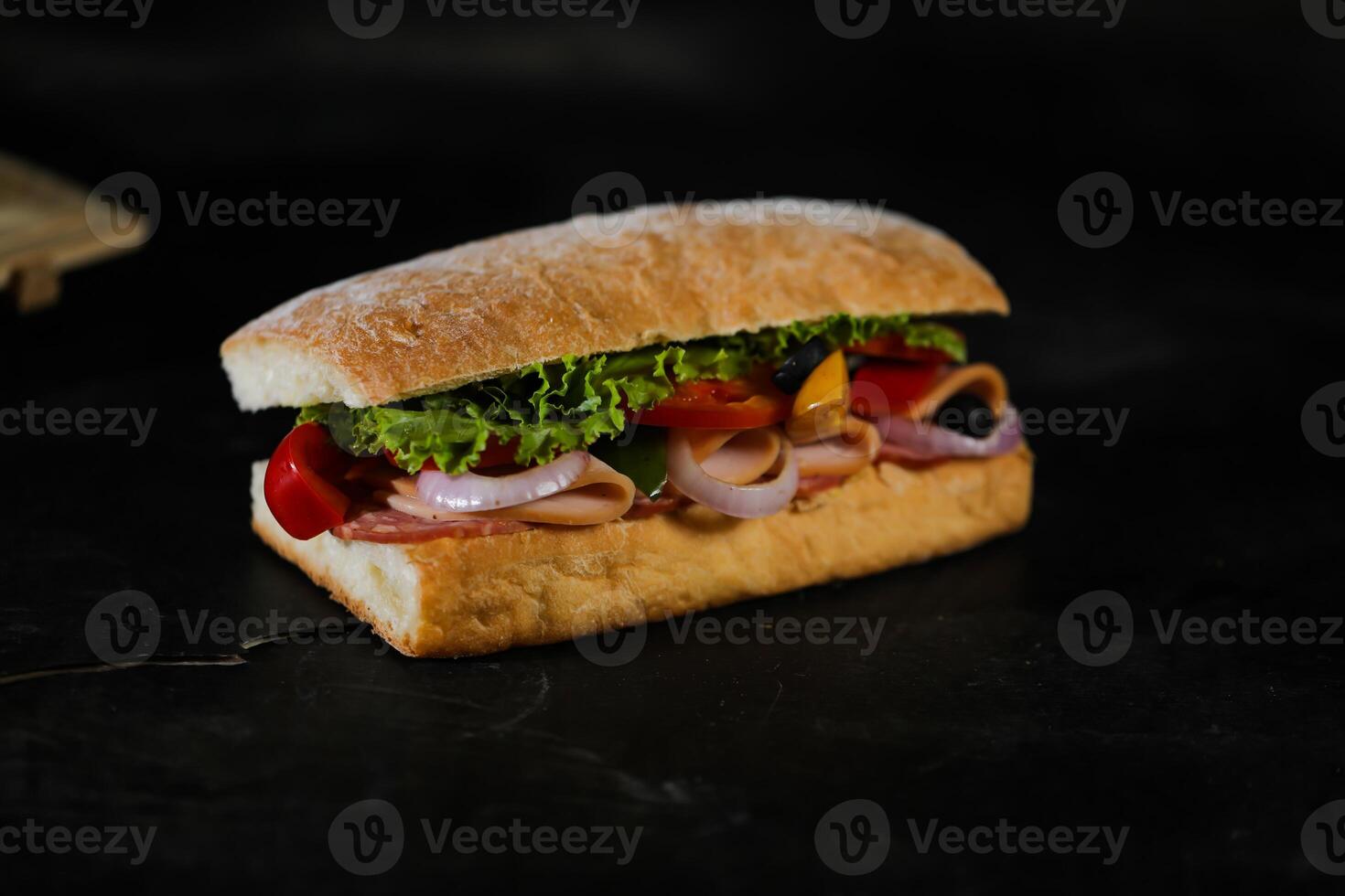Ciabatta Smoked Ham Sandwich isolated on wooden with mayonnaise dip and french fries bucket board side view of italian fast food on grey background photo
