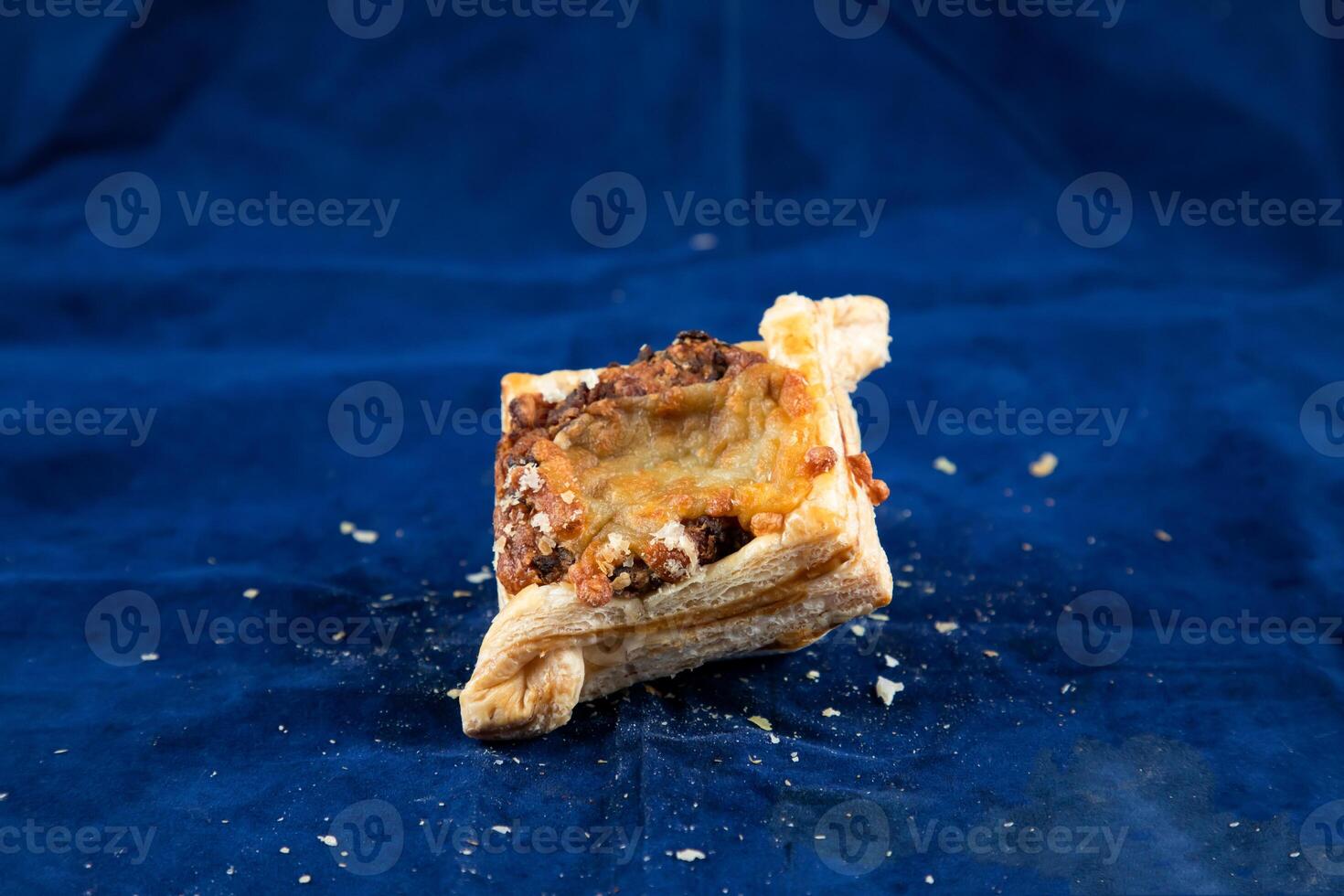 Beef Bacon Puff isolated on blue background side view of savory snack food photo