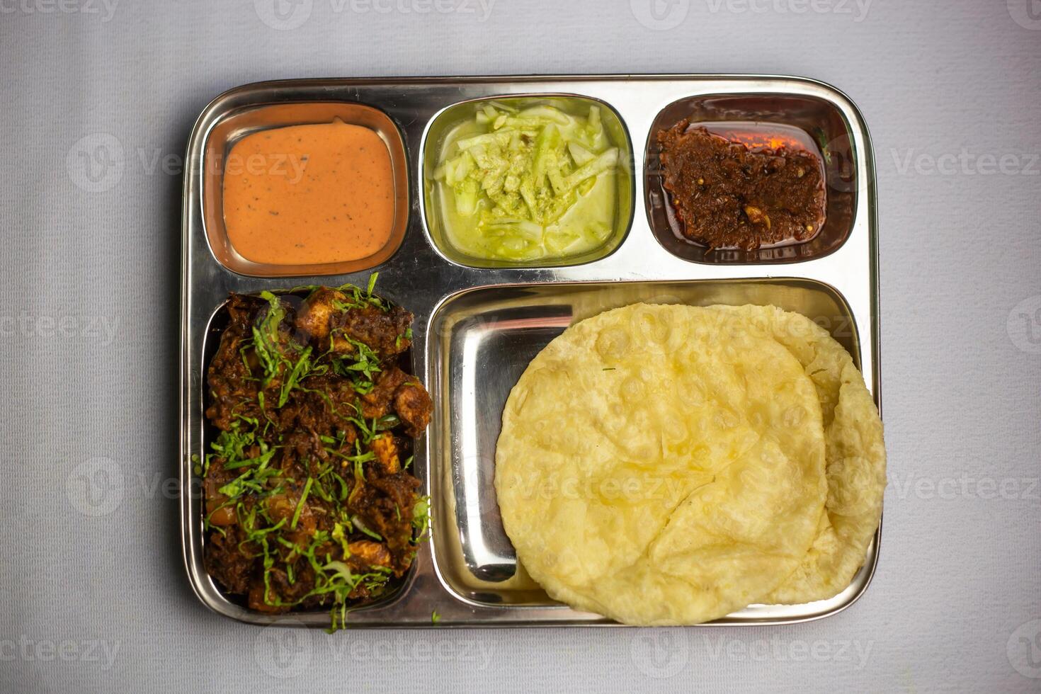 Chicken Masala chaap with Lucchi, chuntney, sauce and chilli dip served in thali platter isolated on background top view of bangladeshi food set menu photo
