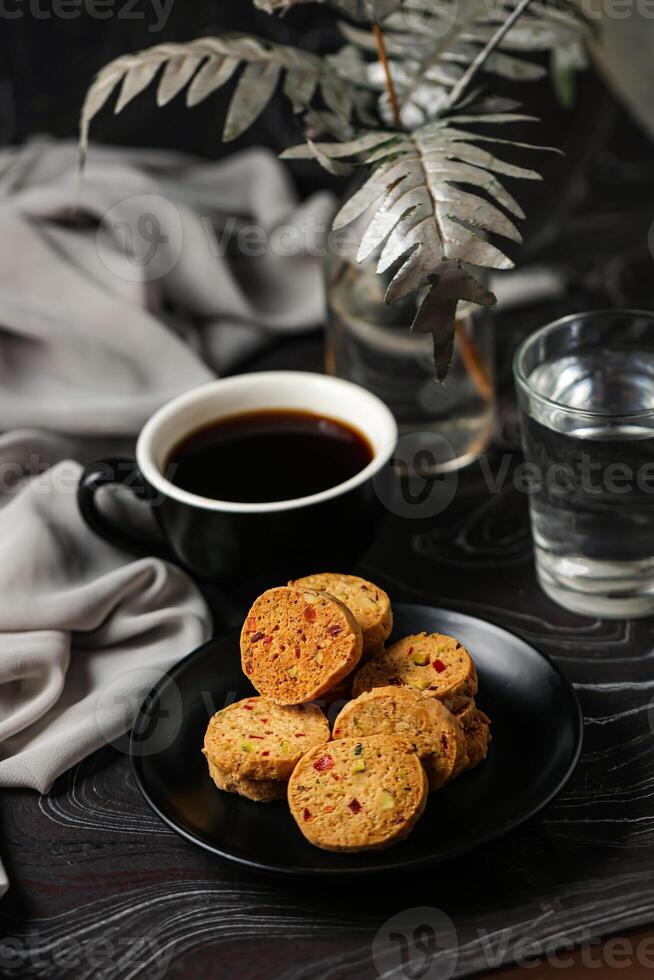 Crunchy cookies biscuits served in plate with black coffee and glass of water isolated on table side view of american cafe baked food photo