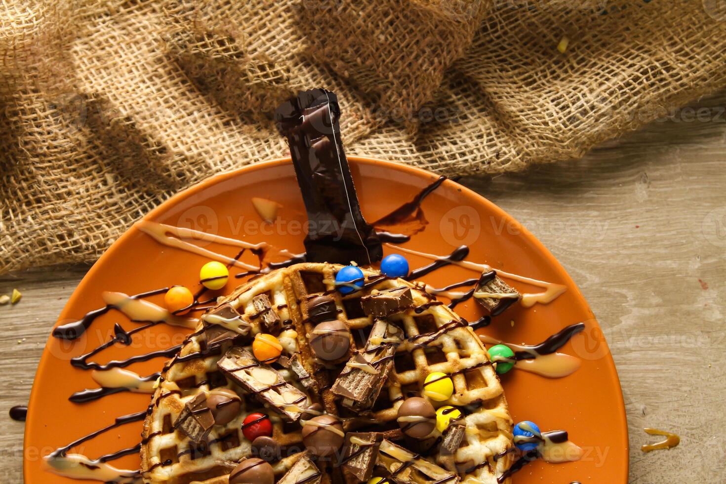 Waffle with Caramel and mix Chocolate served in dish isolated on table top view of cafe snack photo