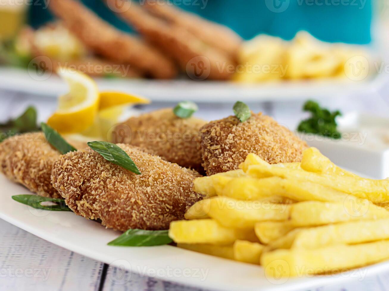 Fried Fish and Chips served in dish isolated on table closeup top view of grilled seafood photo