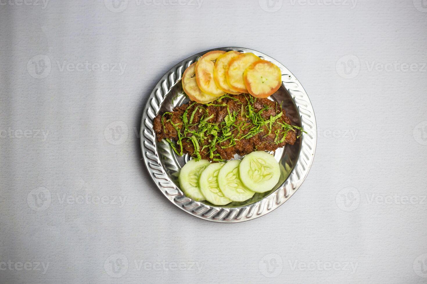 Spicy Beef chaap with tomato and cucumber served in plate isolated on background top view of bangladeshi, indian and pakistani traditional spicy food photo