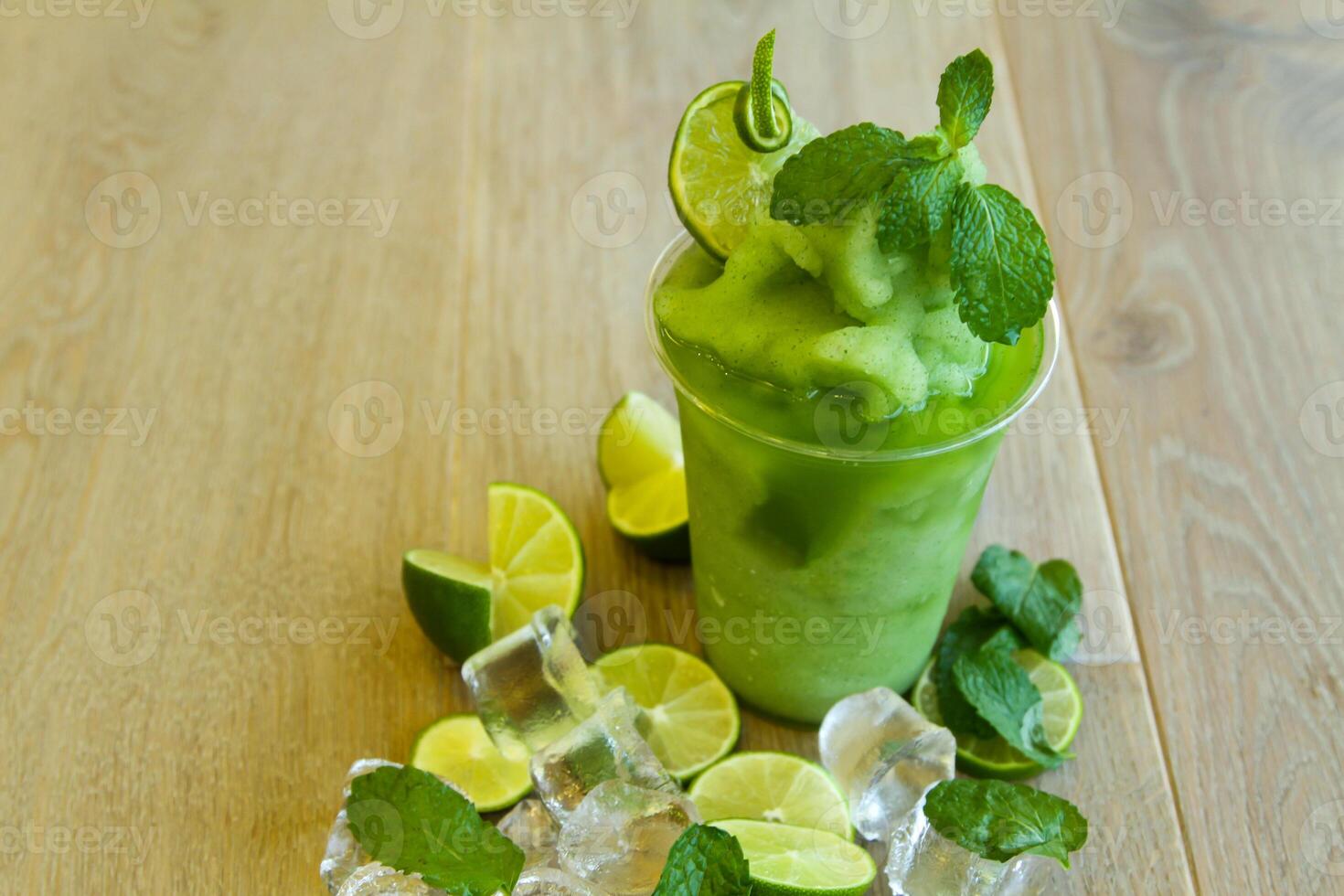 lemon mint smoothie served in disposable glass isolated on table side view of healthy morning smoothie drink photo