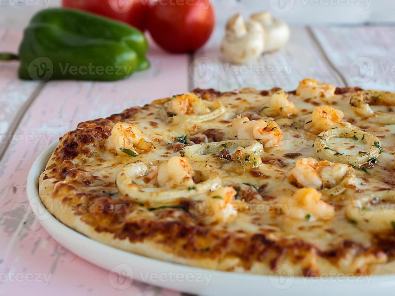 Mariscos Pizza con calamares anillos y gamba Adición con Pimiento, champiñón, tomate y aceitunas servido en plato aislado en mesa lado ver de Arábica comida rápida foto