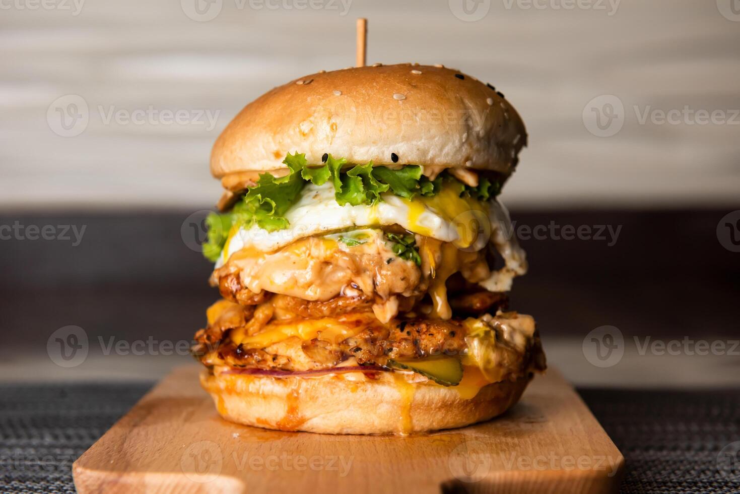 double burger with chicken patties, cheese and mayonnaise isolated on wooden board top view of fastfood photo