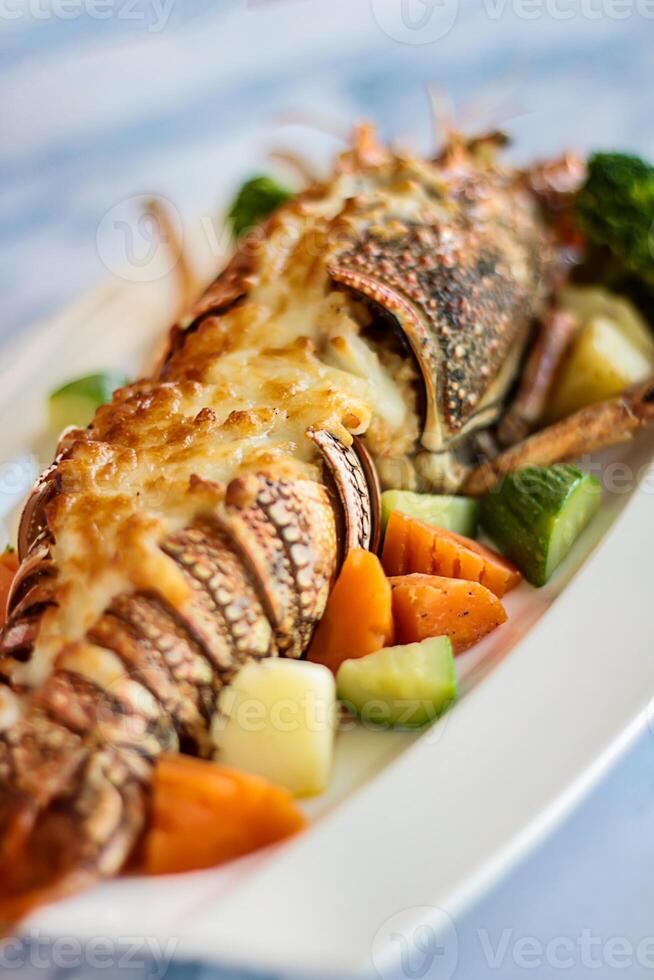 Grilled LOBSTER THERMIDOR served in dish isolated on table closeup top view of grilled seafood photo